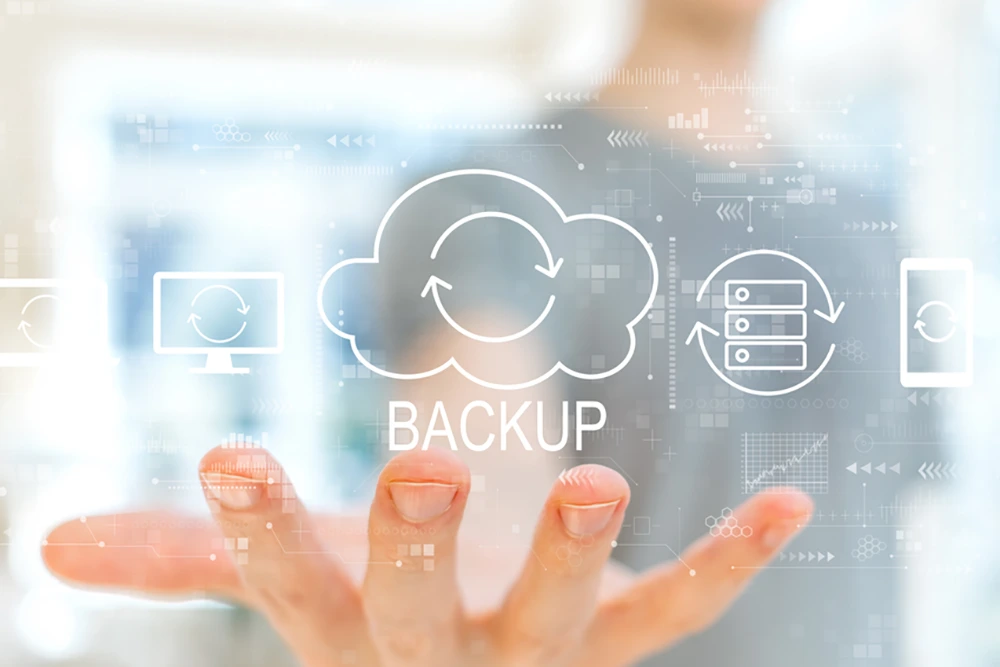 Eine Hand zeigt auf ein digitales Interface mit einem großen Cloud-Backup-Symbol in der Mitte. Um die Wolke sind weitere Icons für Server, Geräte und Synchronisierung angeordnet.