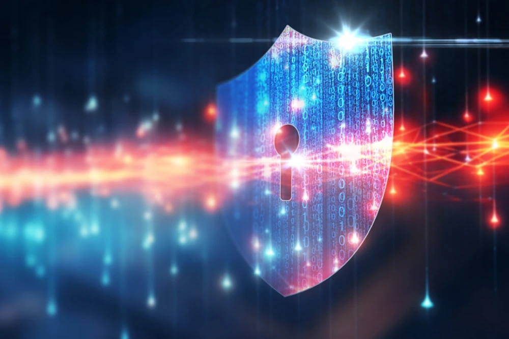 Ein leuchtendes, digitales Schutzschild mit einem Schlüssellochsymbol steht im Zentrum, überlagert von binären Codezeilen. Im Hintergrund verlaufen Lichtstrahlen und Datenströme in Blau- und Rottönen auf dunklem Grund.